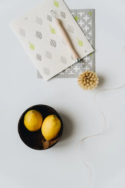 why-choose-us A woman carefully wraps a sofa in protective material while packing boxes in a bright room.